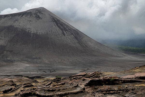 Active volcano under white clouds in Tanna, Vanuatu by Seiji Seiji