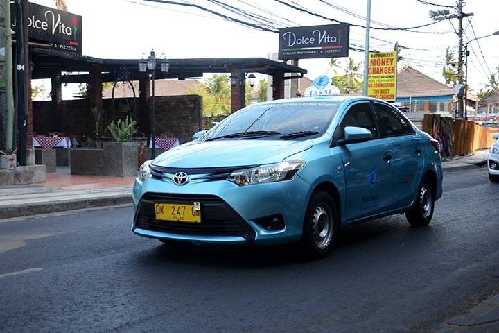  Bluebird Taxi travelling on the street of Bali.